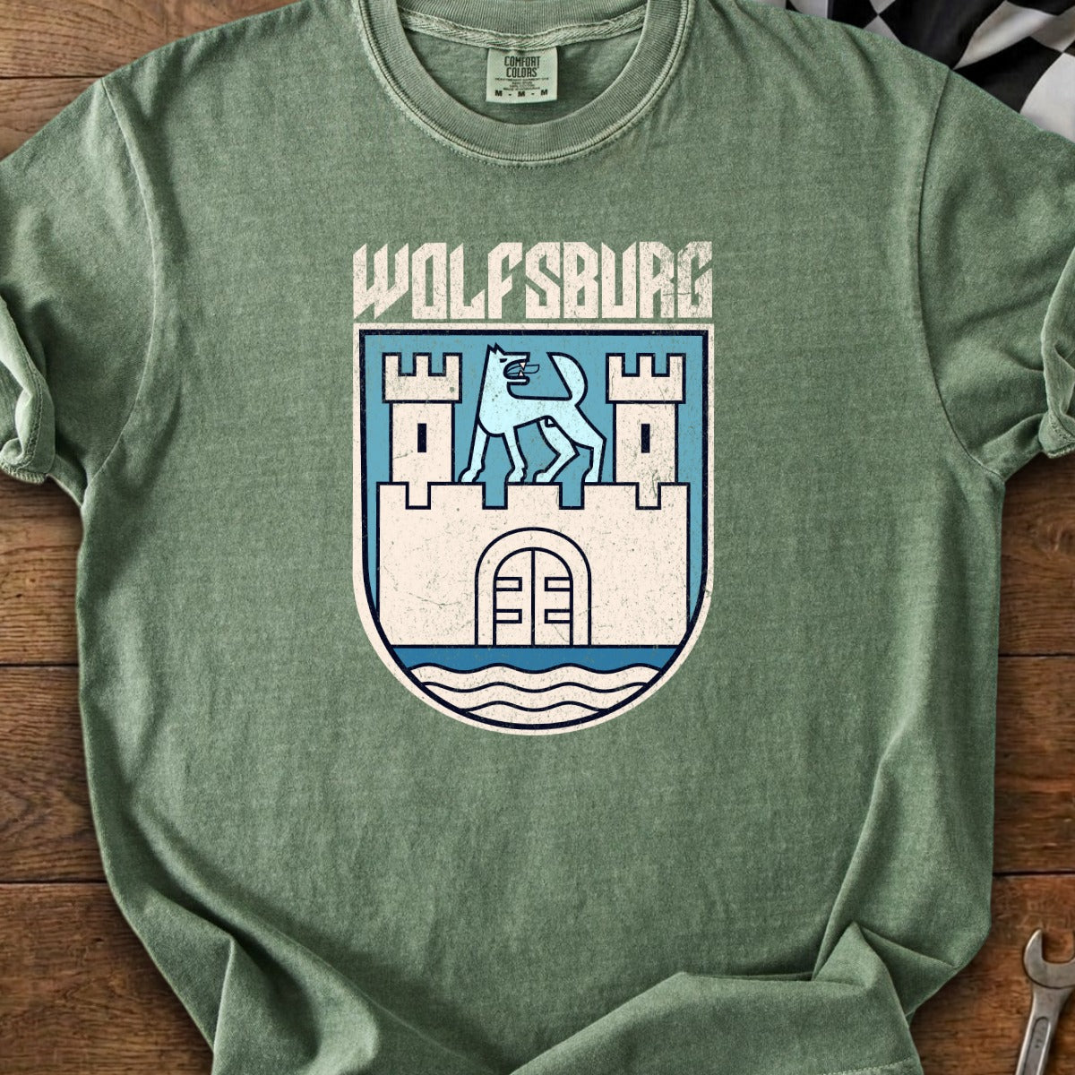 Green t-shirt with "WOLFSBURG" text over a coat of arms featuring a blue wolf.