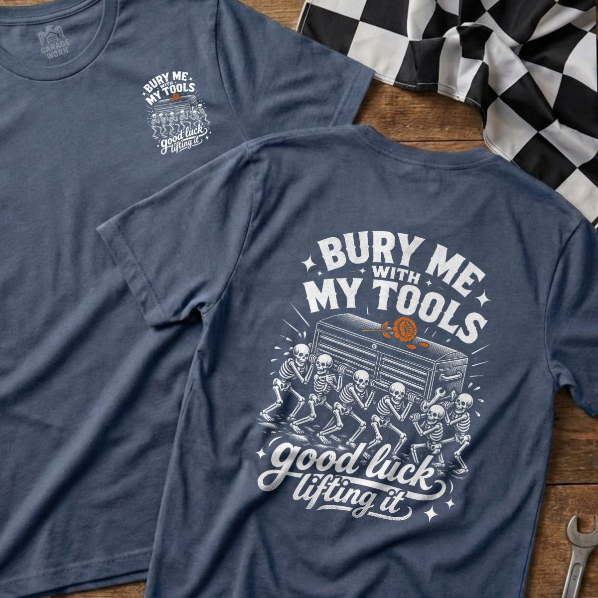 Blue t-shirt with white graphic of skeletons carrying a toolbox, reading "Bury Me With My Tools" and "Good Luck Lifting It".