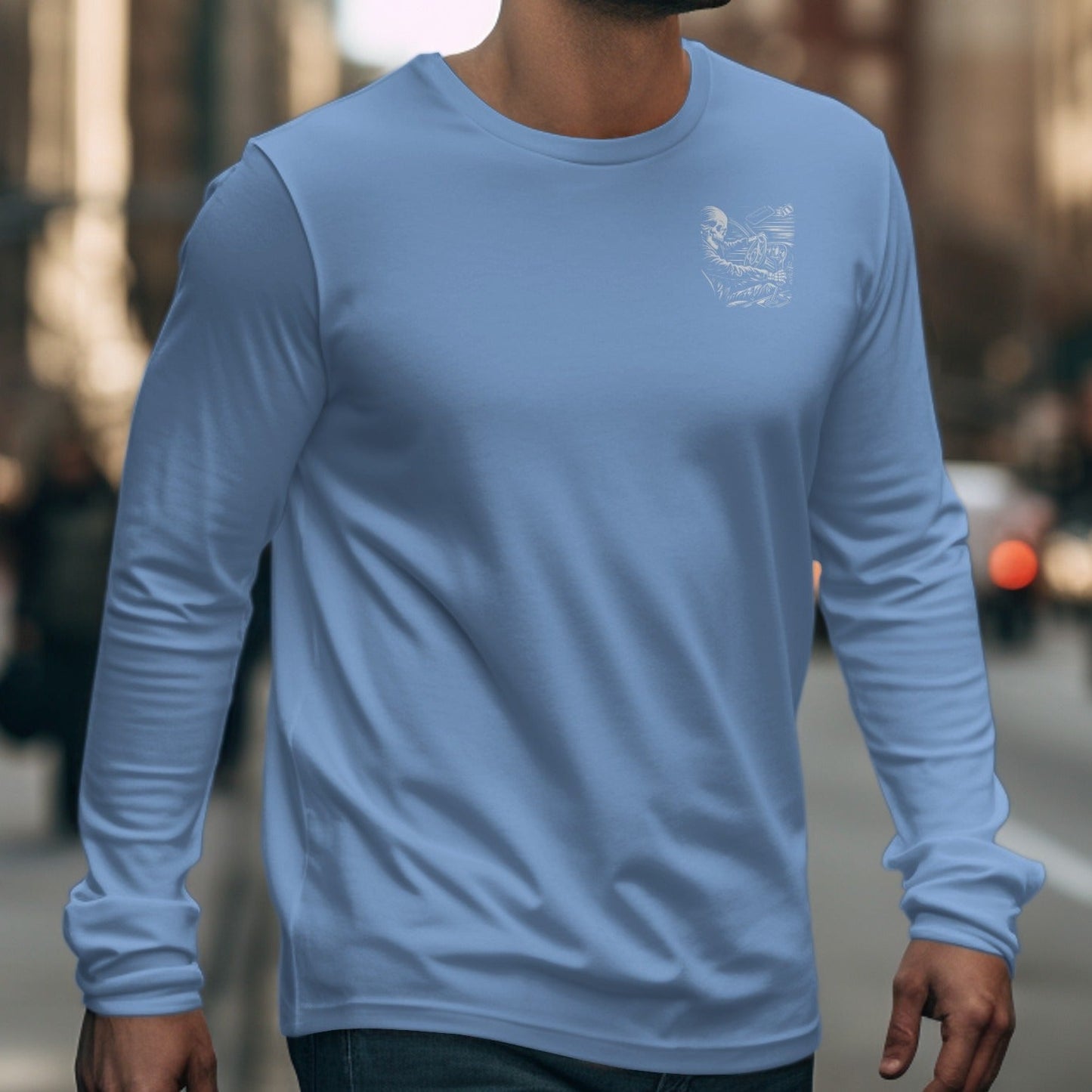 Light blue long-sleeved shirt with a white graphic of a skeleton driving a car on the chest.
