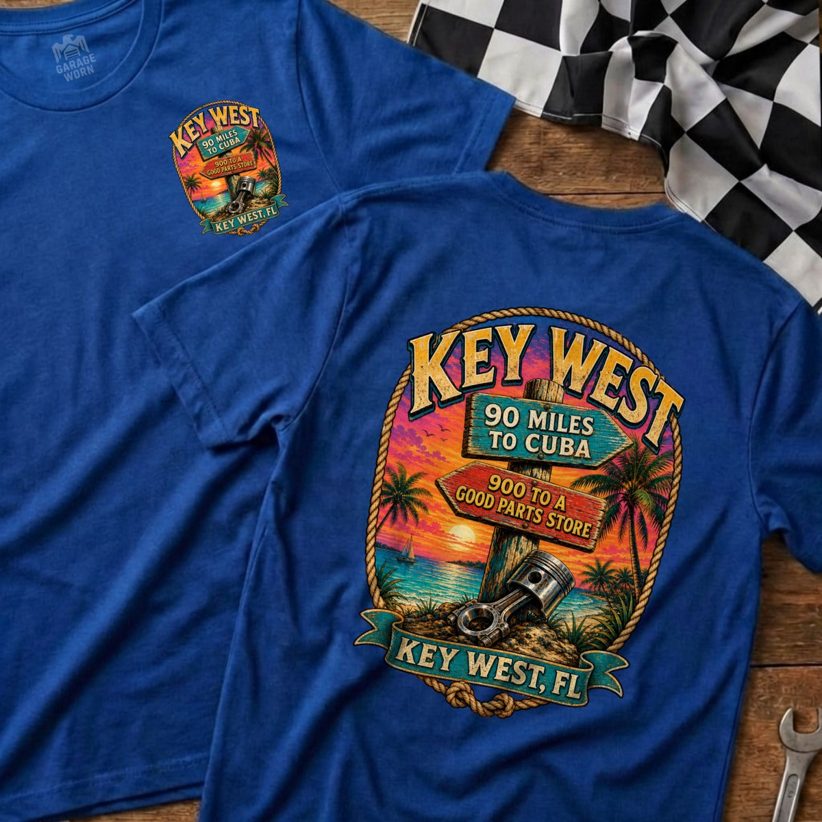 Blue t-shirt with Key West graphic featuring sunset, palm trees, and road signs.