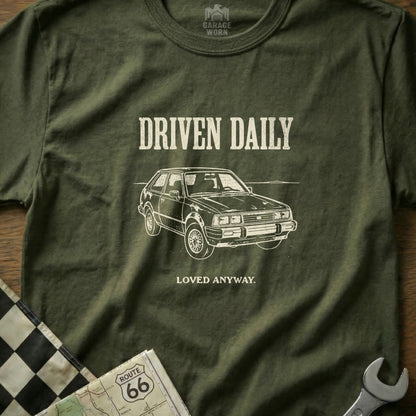 Olive t-shirt with "Driven Daily" and a car illustration.