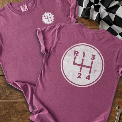 Purple t-shirts with a white manual gear shift pattern graphic.