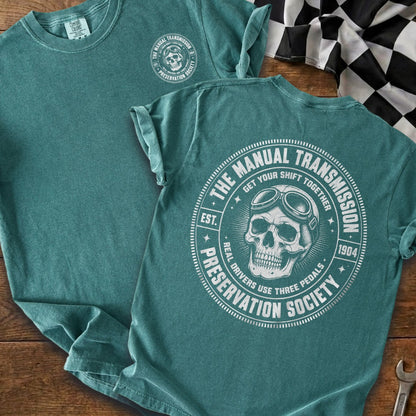 Teal t-shirt with a skull wearing goggles and "Manual Transmission Preservation Society" text.