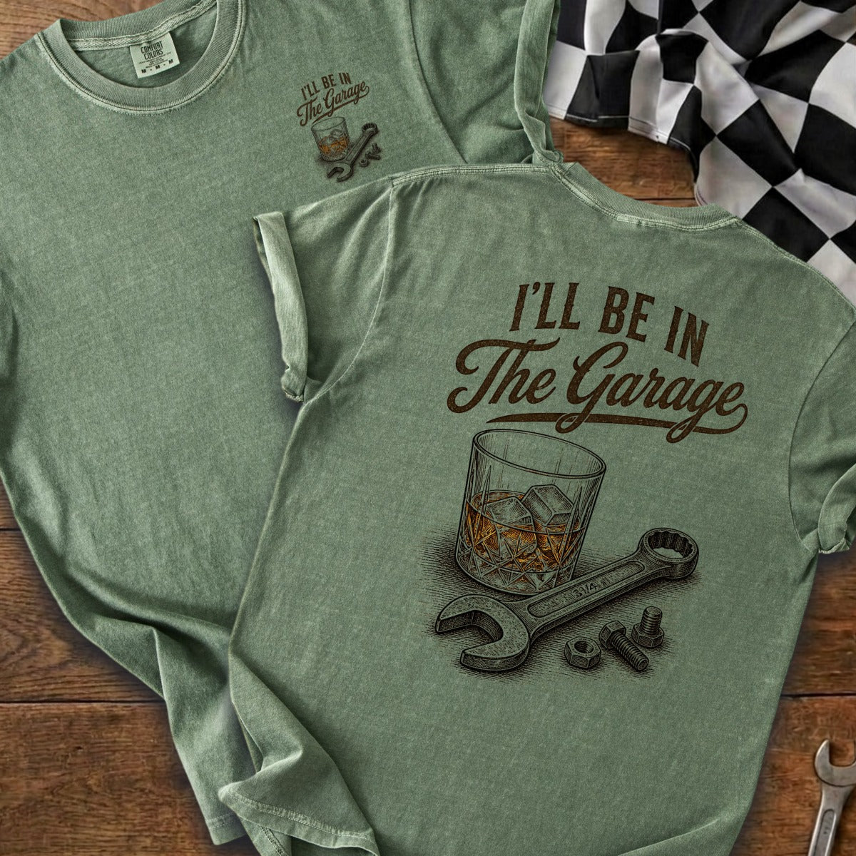 Green t-shirt with "I'll Be In The Garage" text, whiskey glass, wrench, and nuts.