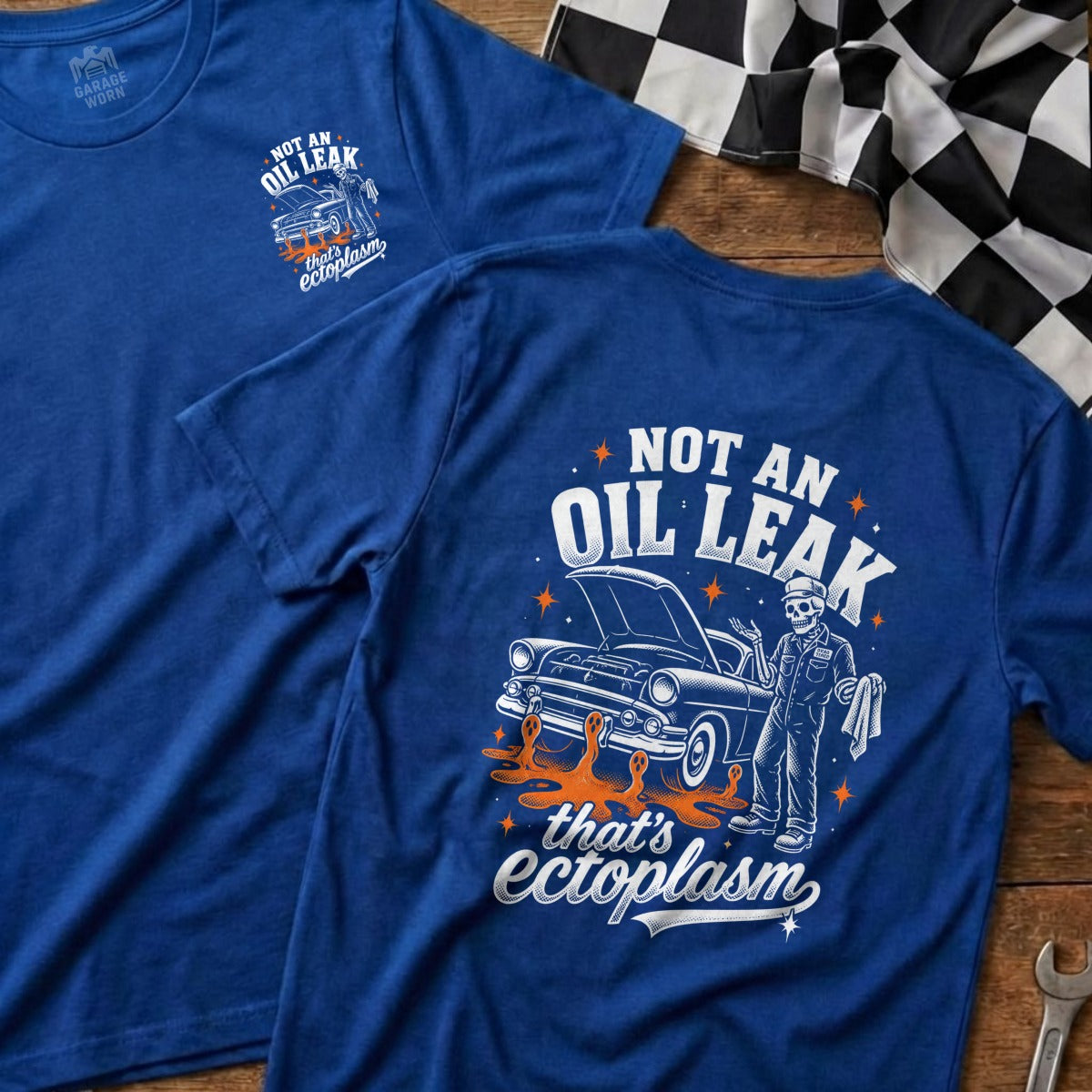 Blue t-shirt with graphic: skeleton mechanic and classic car, "Not an oil leak that's ectoplasm."