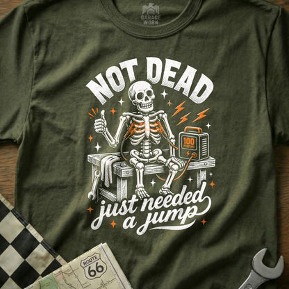 T-shirt graphic: skeleton with jumper cables, "Not Dead, Just Needed a Jump."