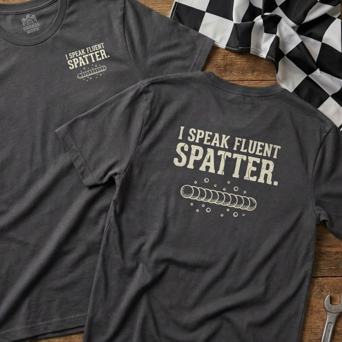 Dark grey t-shirt with "I SPEAK FLUENT SPATTER" and weld bead graphic.