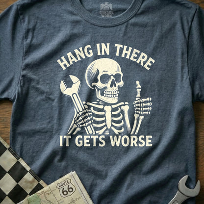 Blue t-shirt with skeleton holding wrench and thumbs up, text "Hang in there, it gets worse."