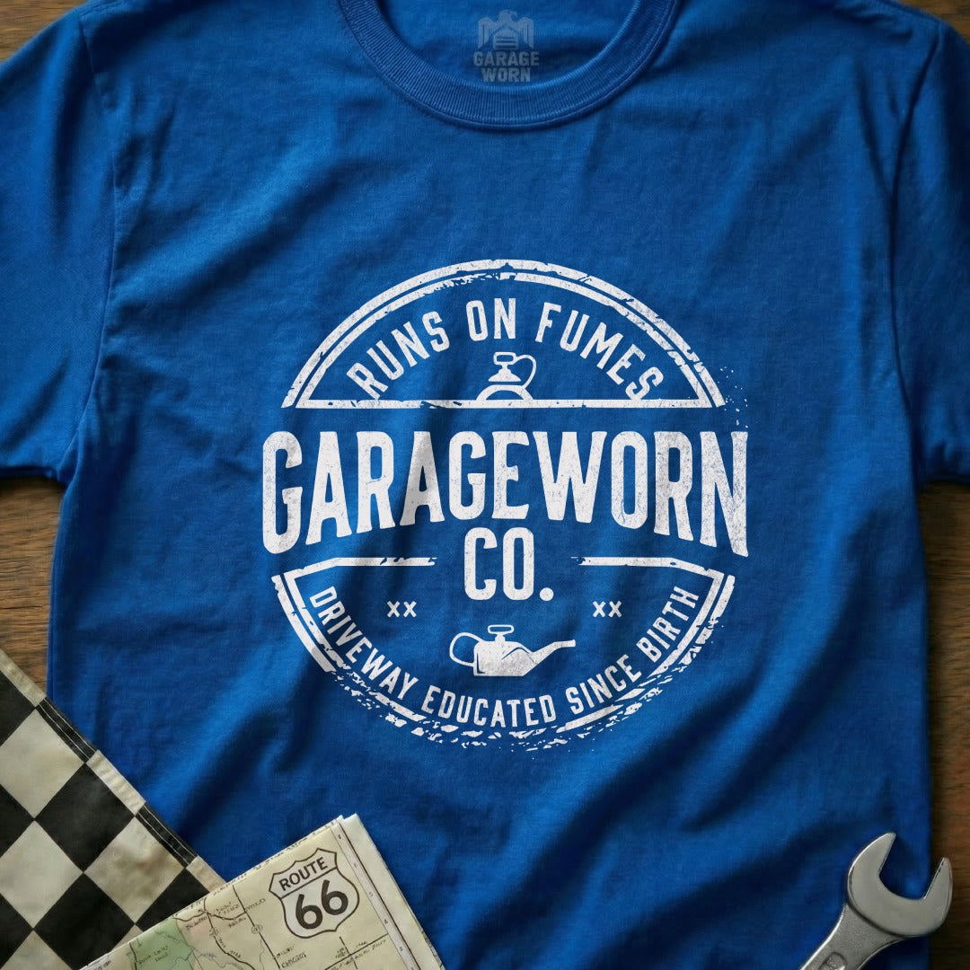 Blue t-shirt with "GARAGEWORN CO." logo, "Runs on Fumes," and "Driveway Educated Since Birth" text.