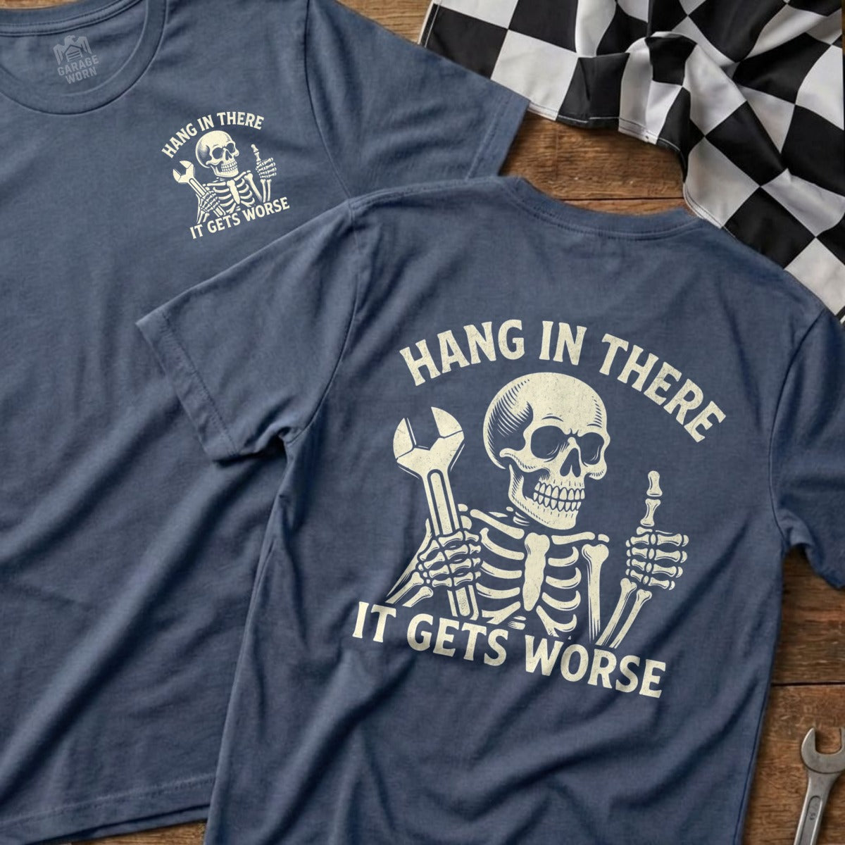 Two navy t-shirts with a skeleton holding a wrench and text "Hang in There It Gets Worse".