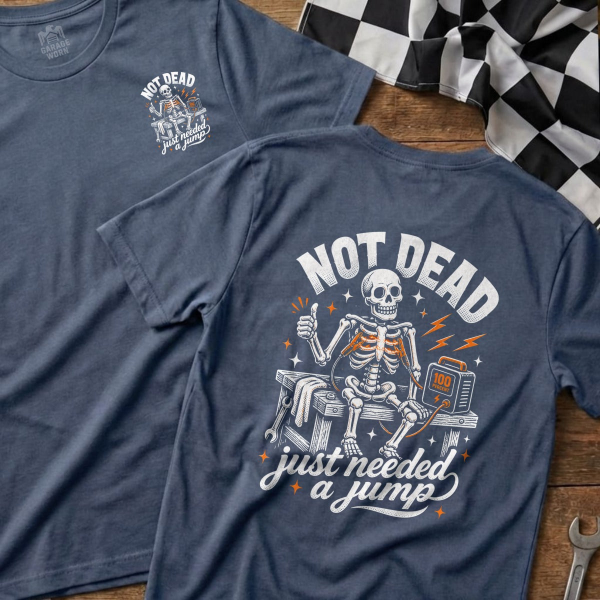 Skeleton with jumper cables and "NOT DEAD" text on a navy t-shirt.