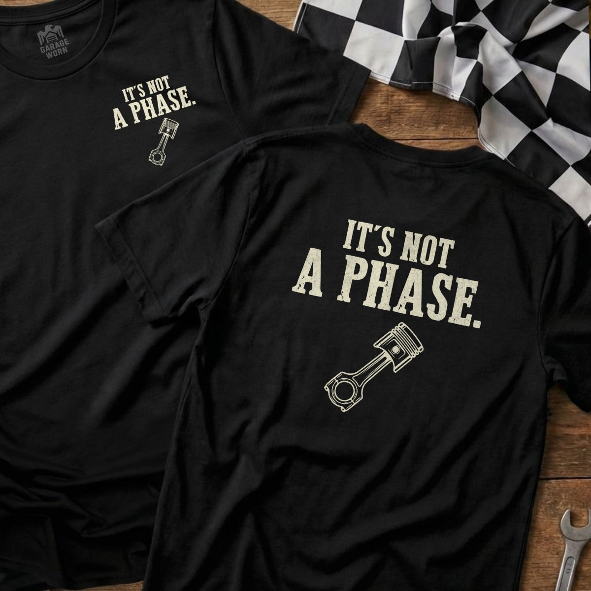Black t-shirt with "IT'S NOT A PHASE." and piston graphic.
