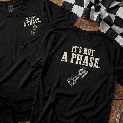 Black t-shirt with "IT'S NOT A PHASE." and piston graphic.