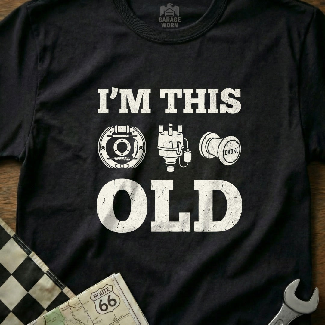 Black t-shirt with white text "I'M THIS OLD" and vintage auto part graphics.