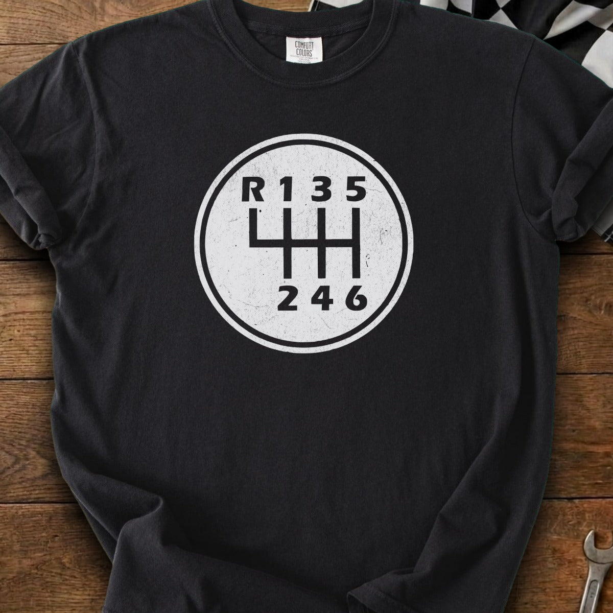 Black t-shirt with white circular graphic of a 6-speed manual transmission shift pattern.