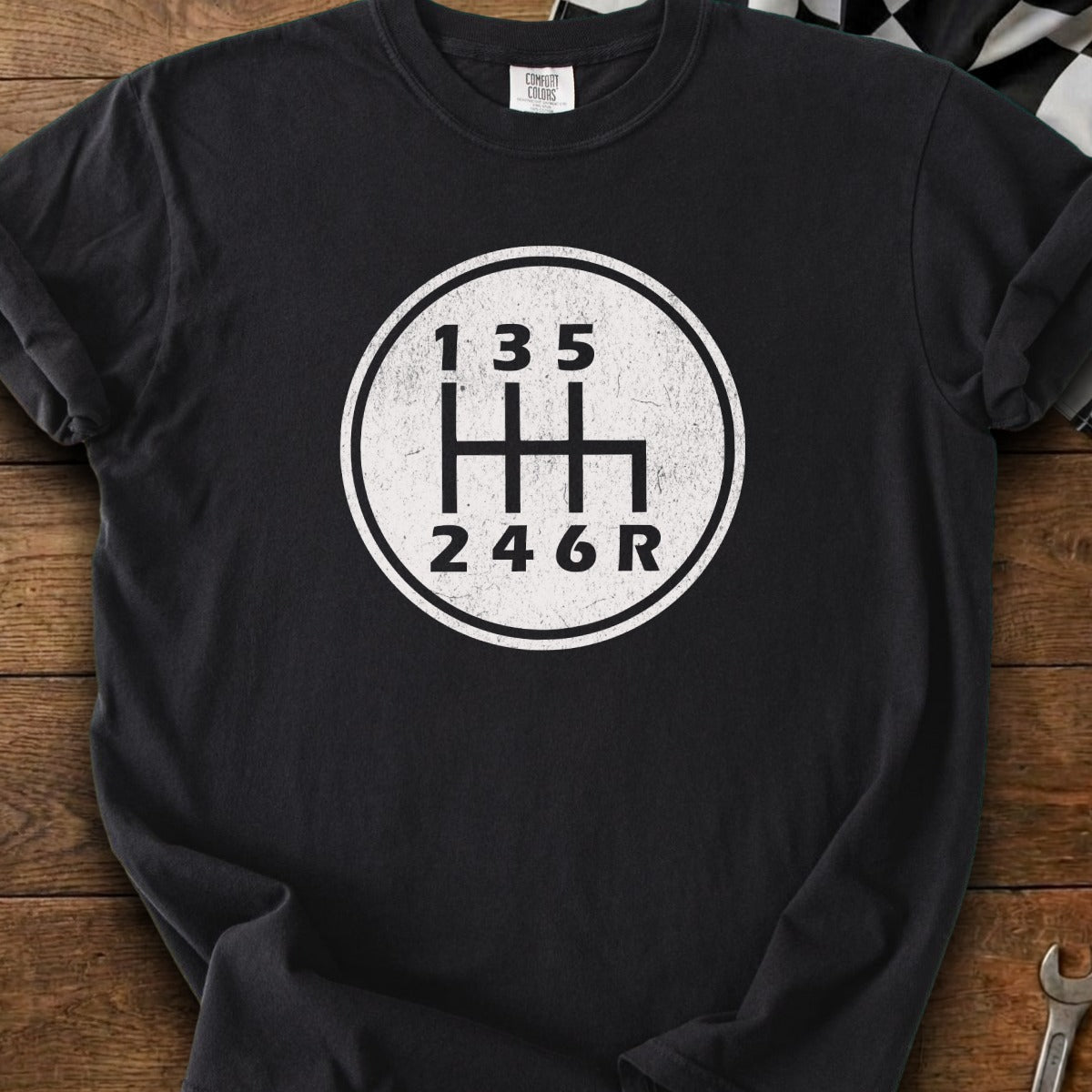 Black t-shirt with a white graphic of a 6-speed manual transmission shift pattern.