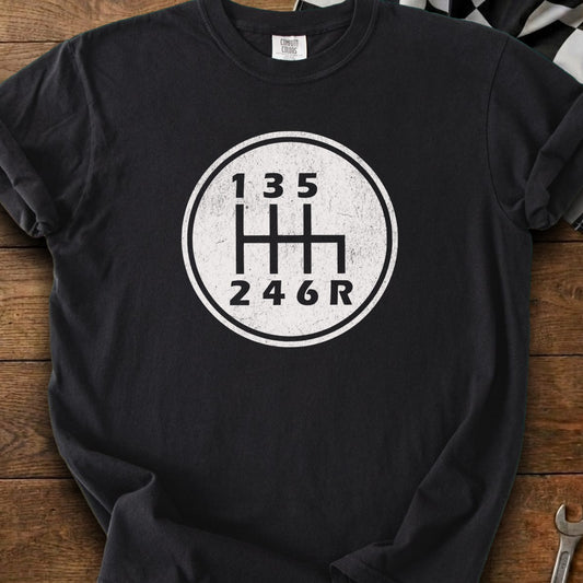 Black t-shirt with a white graphic of a 6-speed manual transmission shift pattern.