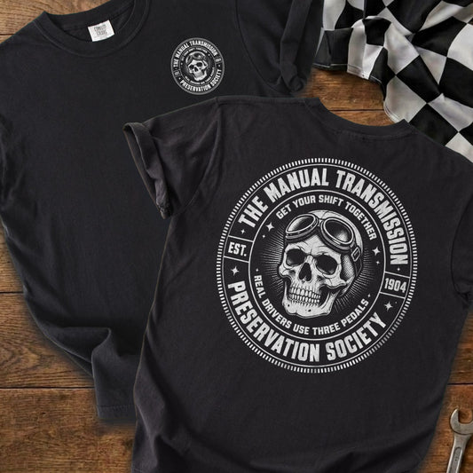 Black t-shirt with white skull wearing goggles and circle design about manual transmissions.