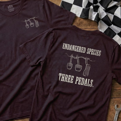 Dark t-shirt with "ENDANGERED SPECIES THREE PEDALS" and pedal graphic.