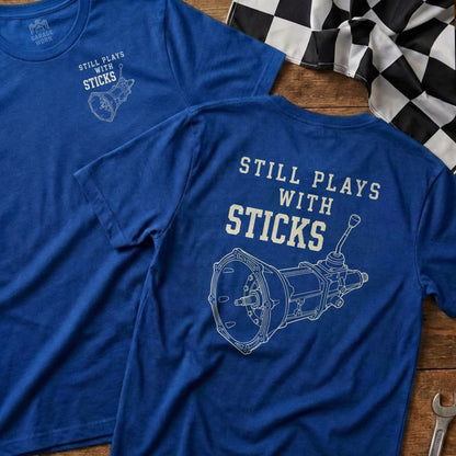 Blue t-shirt with "Still plays with sticks" and manual transmission graphic.