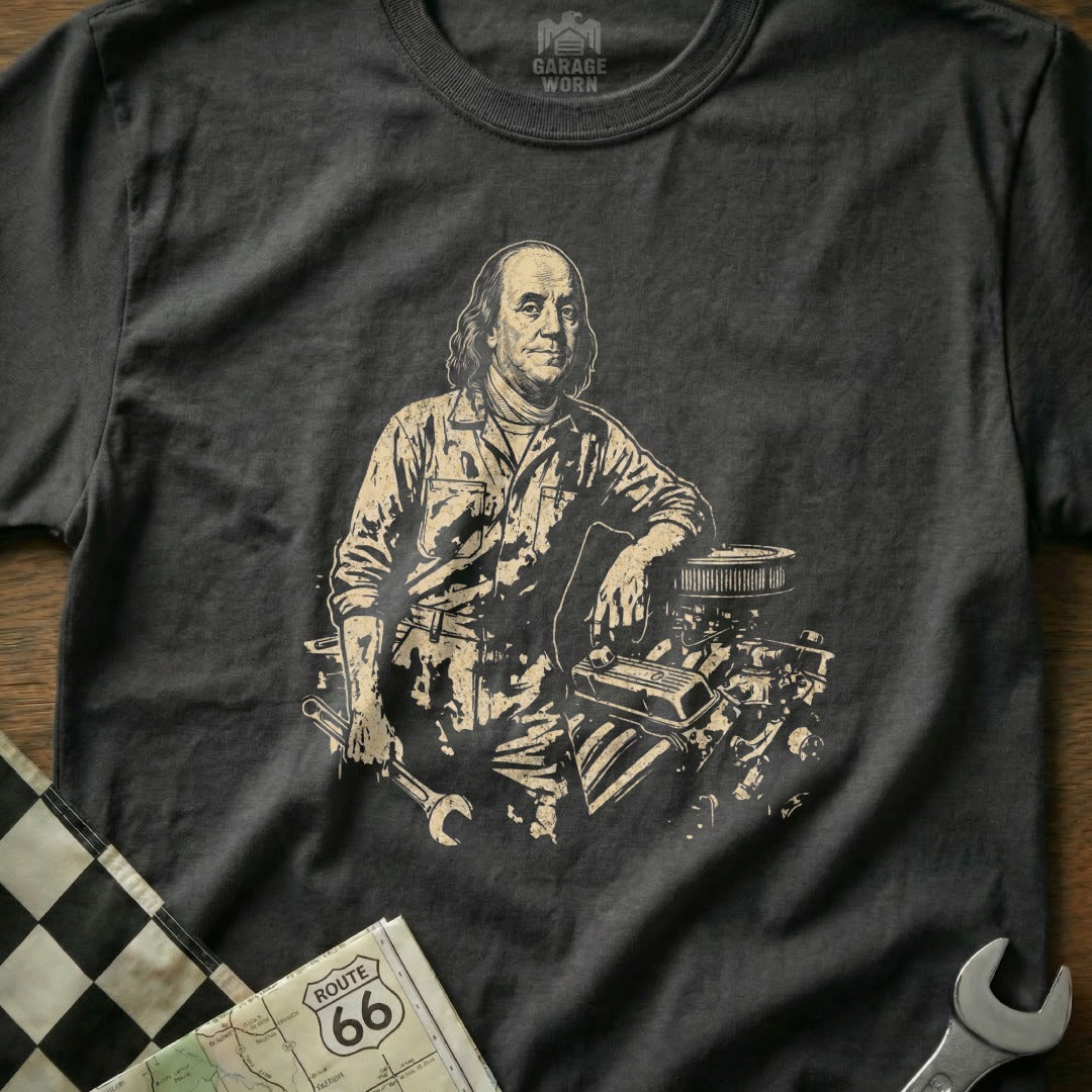 Benjamin Franklin in mechanic's overalls leans on an engine, holding a wrench.
