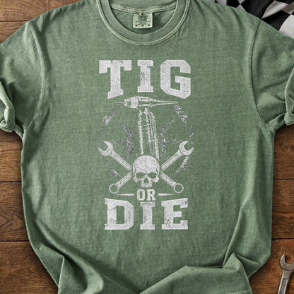 Green t-shirt with "TIG OR DIE" graphic featuring a skull, welder, and wrenches.