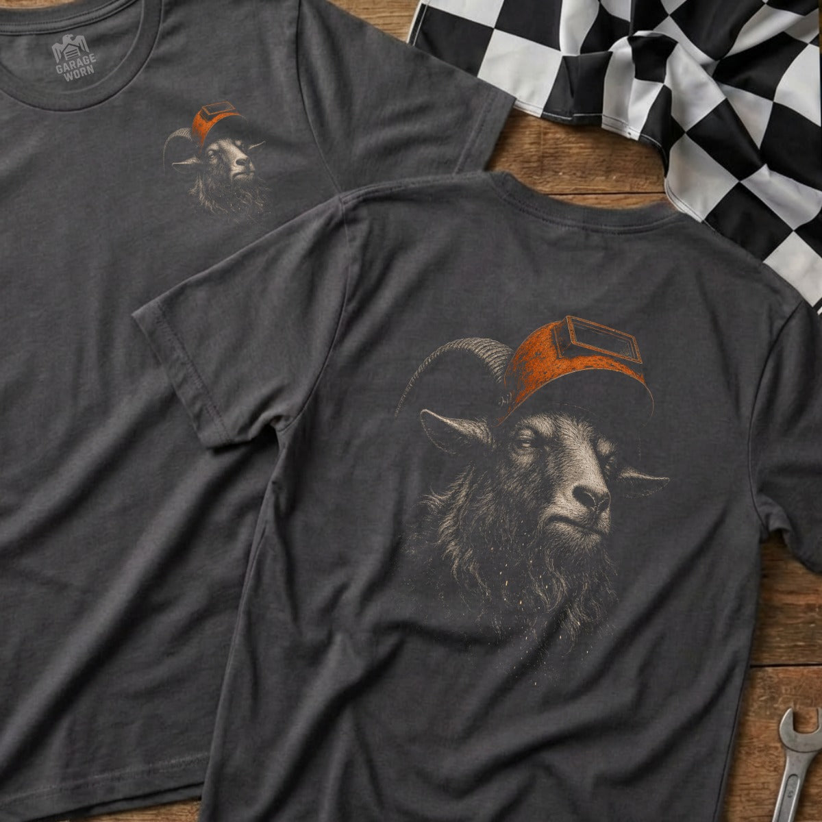 Charcoal t-shirt with detailed goat graphic wearing a welding mask and orange cap.