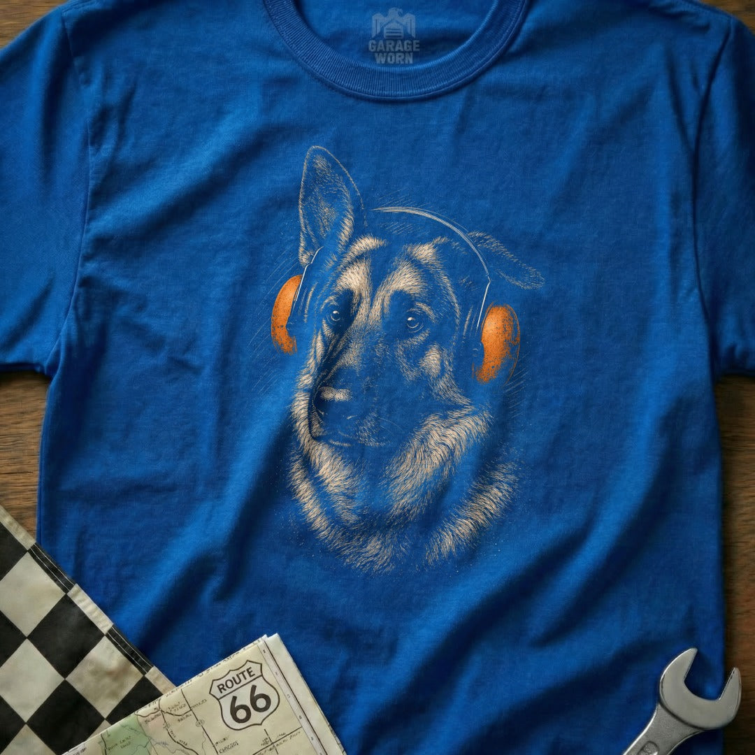 German Shepherd wearing orange headphones on a blue t-shirt.