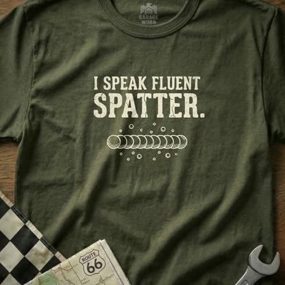 Green t-shirt with "I SPEAK FLUENT SPATTER." text and welding graphic.