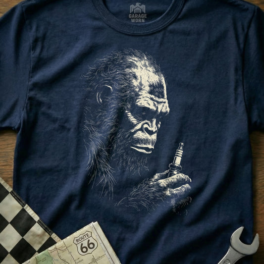Navy t-shirt with a sketch of Bigfoot holding a spark plug.