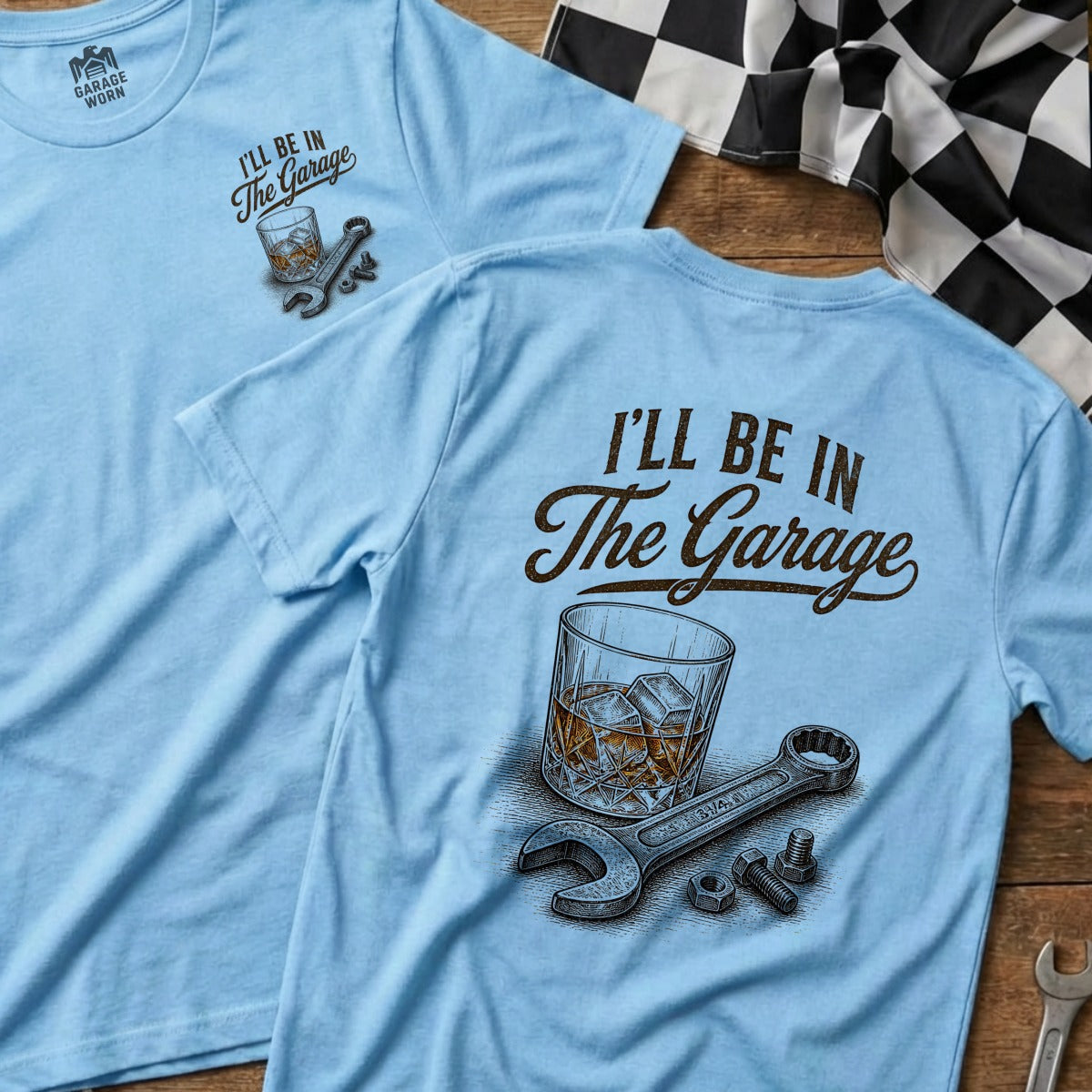 Light blue t-shirt with "I'll Be In The Garage" text, whiskey glass, and wrench.