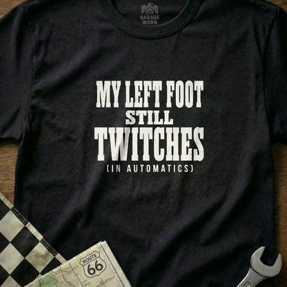 Black t-shirt with white text "My left foot still twitches (in automatics)".