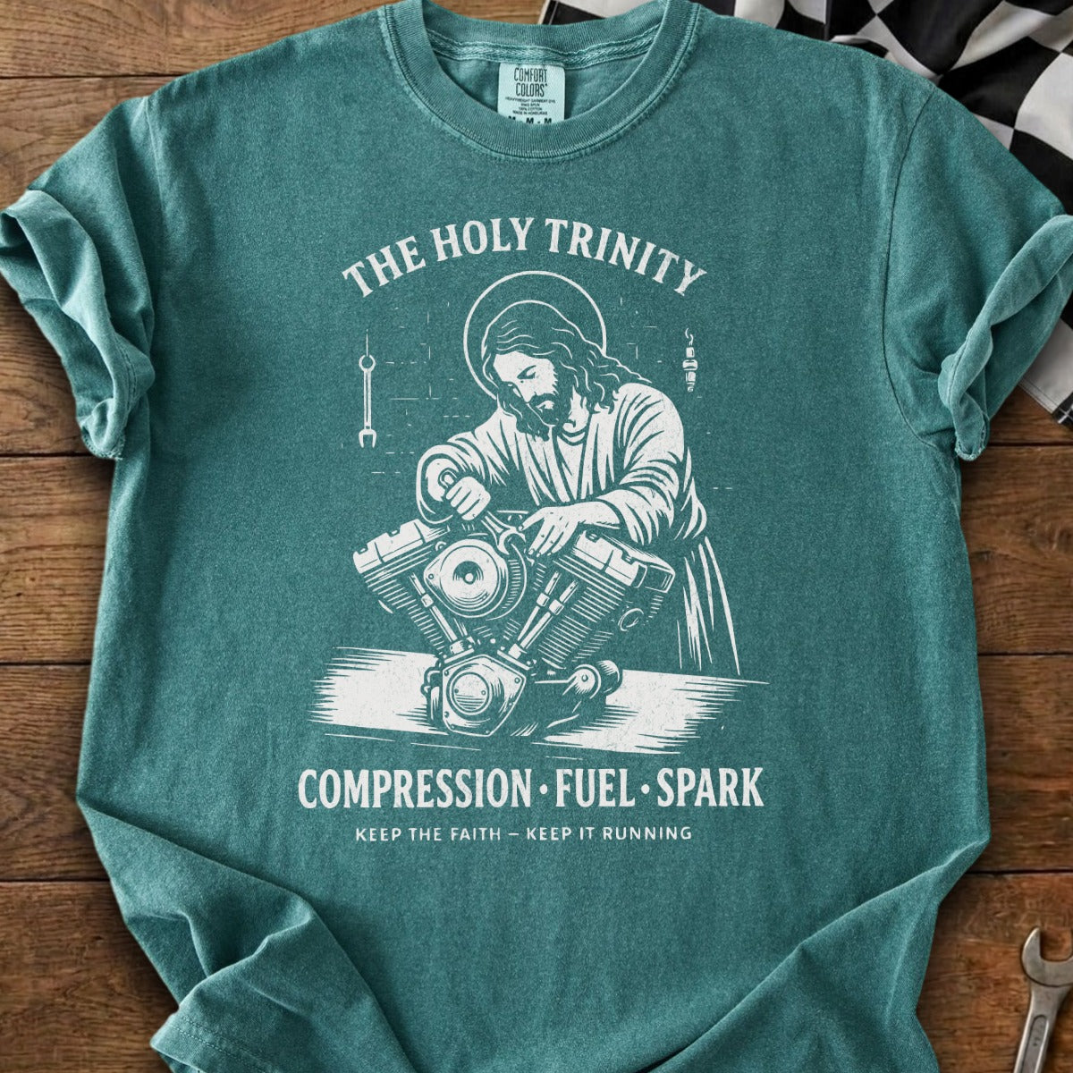 Jesus working on a motorcycle engine with text "The Holy Trinity".