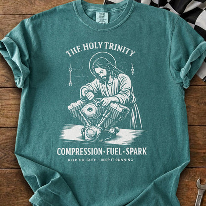 Jesus working on a motorcycle engine with text "The Holy Trinity".