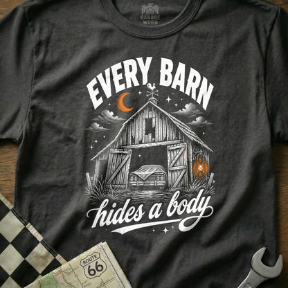 T-shirt graphic with barn, covered car, moon, and text "EVERY BARN hides a body."