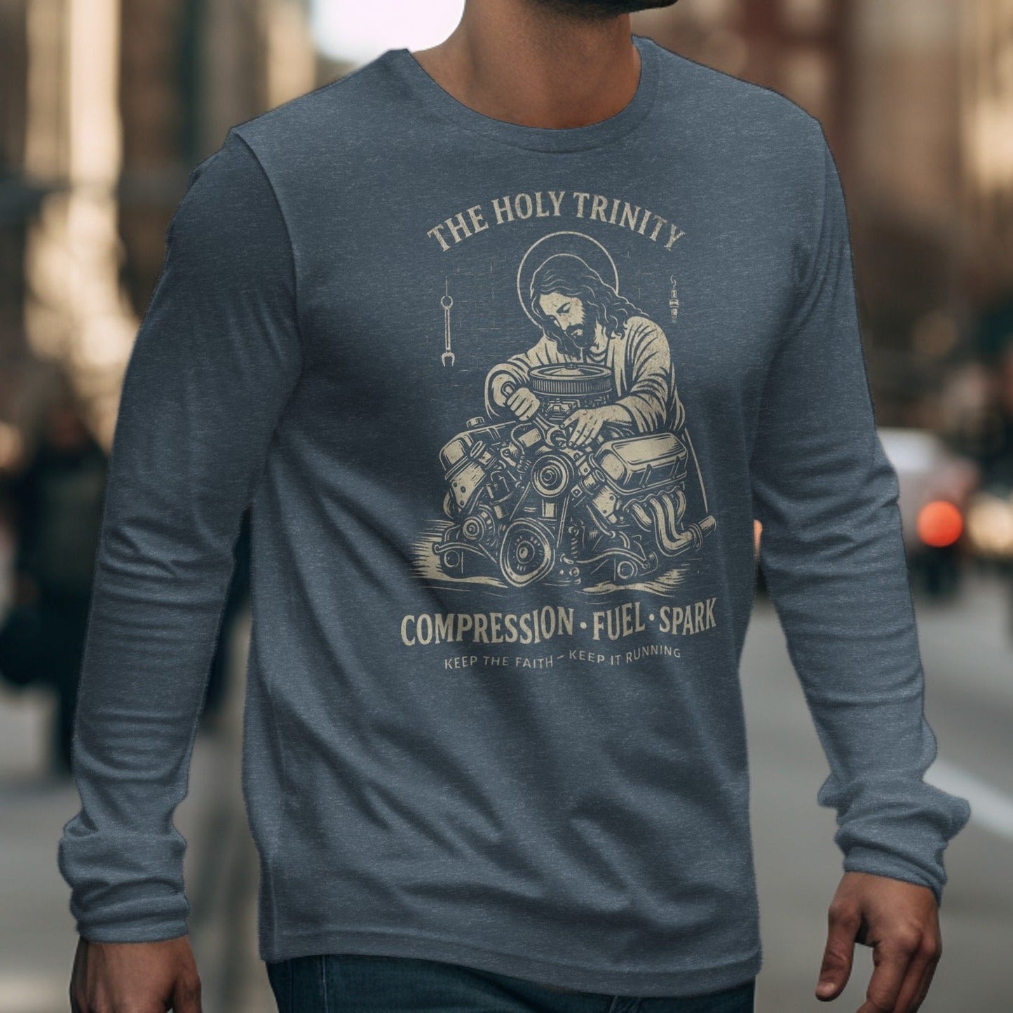 Jesus with halo working on an engine graphic on a long sleeve shirt.