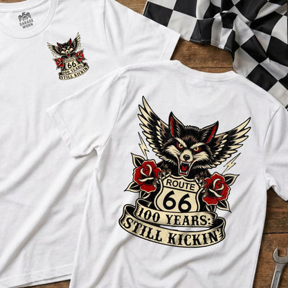 White t-shirts featuring Route 66 logo, wolf, and "100 Years: Still Kickin'" text.