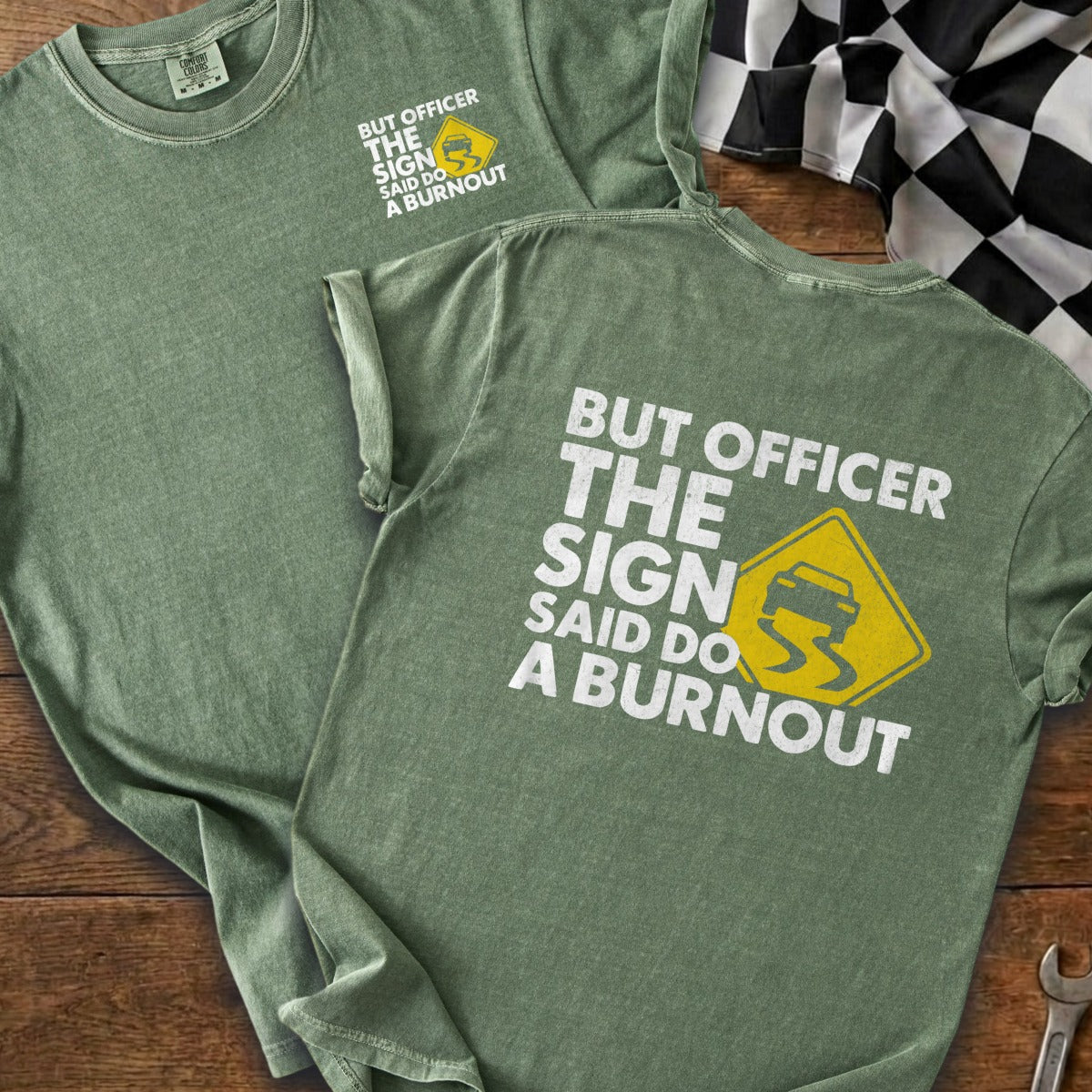 Green t-shirt with white text and a yellow slippery car symbol saying "But officer the sign said do a burnout".
