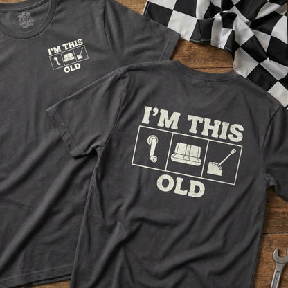 Dark grey t-shirt with "I'M THIS OLD" text and vintage car parts icons.