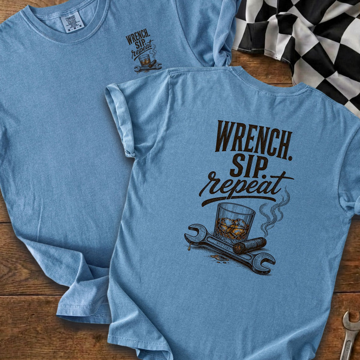 Blue t-shirt with "Wrench. Sip. Repeat." text and graphic of a cigar, whiskey, and wrenches.
