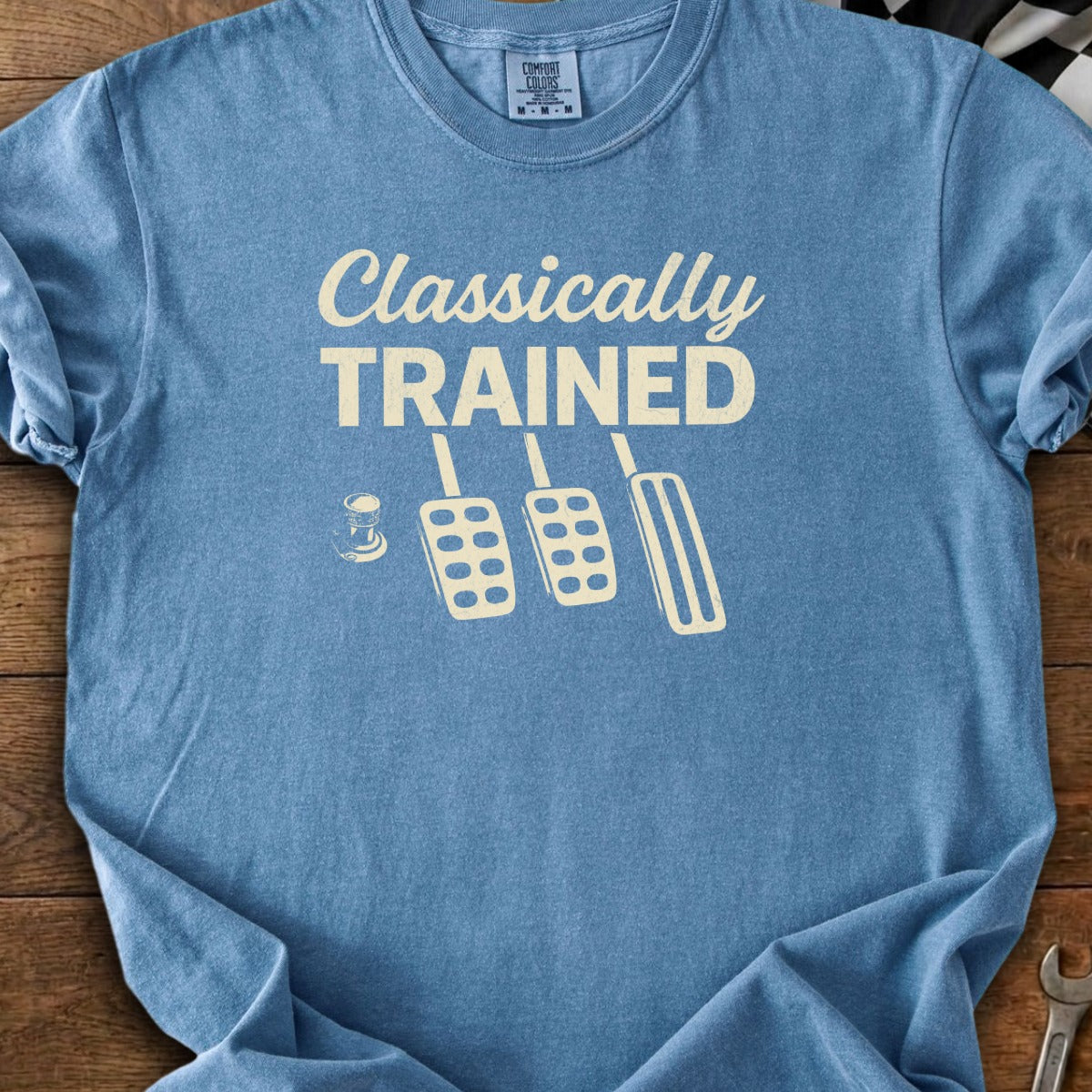 Blue t-shirt with "Classically TRAINED" and clutch, brake, gas pedals.