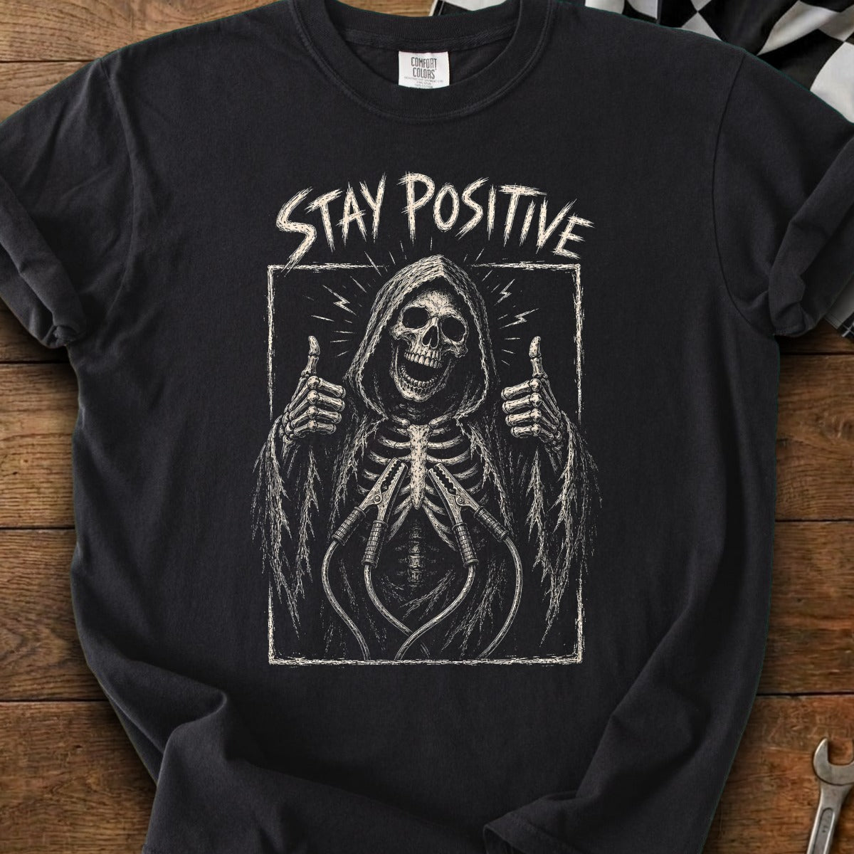 Black t-shirt with grim reaper skeleton giving thumbs up and text "STAY POSITIVE".