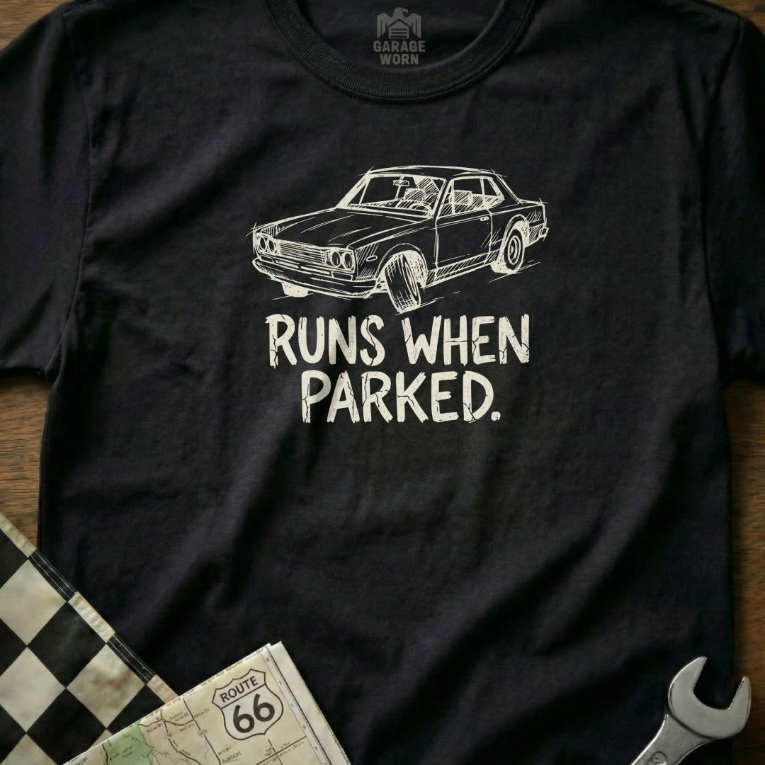 Black t-shirt with white sketch of a car and text "RUNS WHEN PARKED."