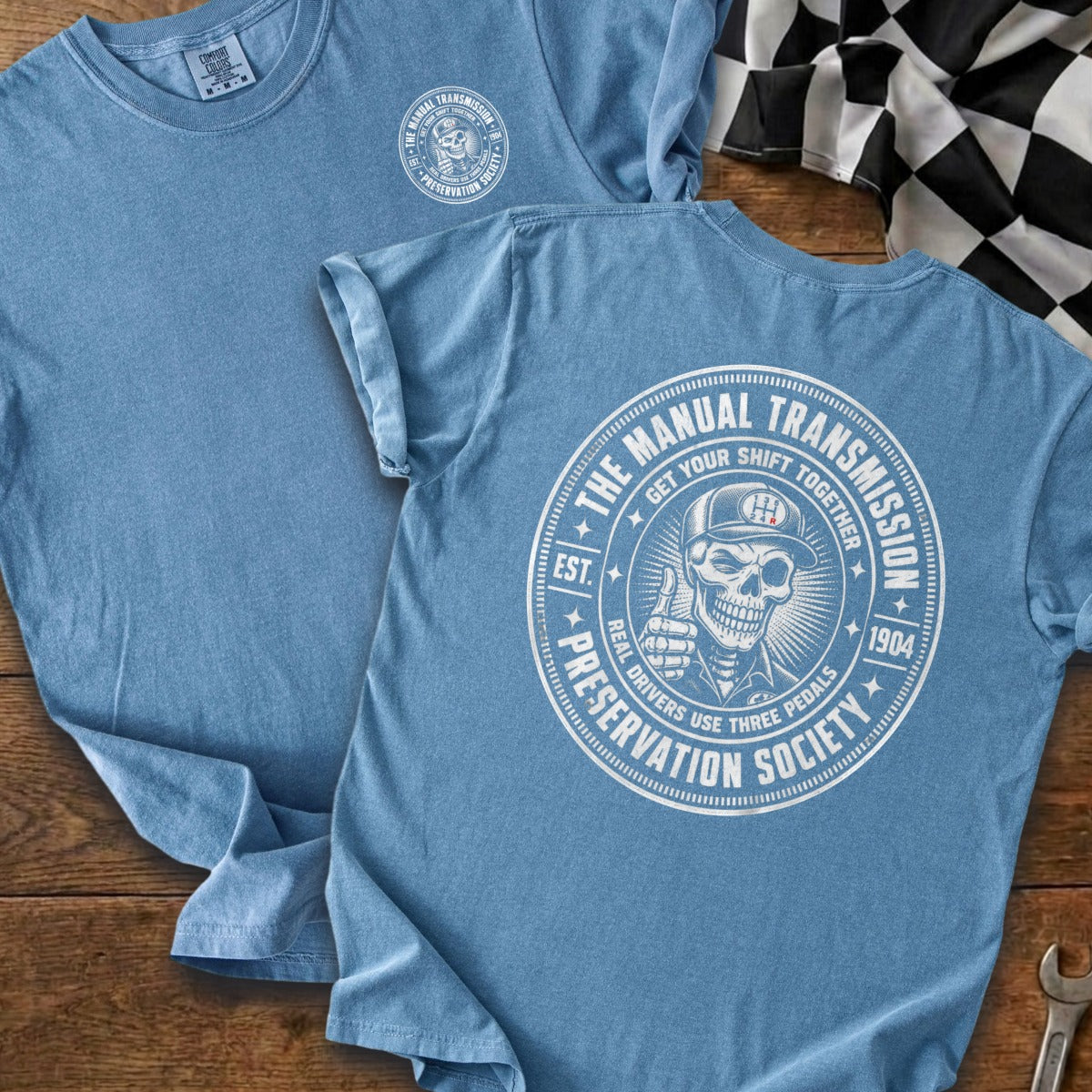 Blue t-shirt with a circular graphic featuring a skeleton giving a thumbs up and text.