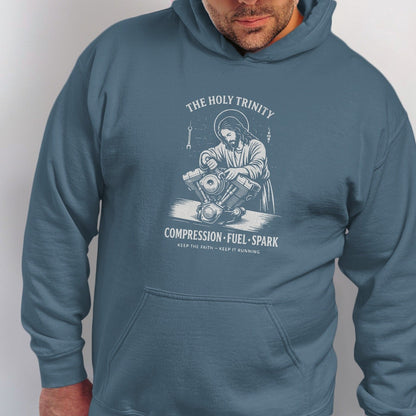 The Holy Trinity Compression Fuel Spark hoodie features Jesus working on a motorcycle engine.