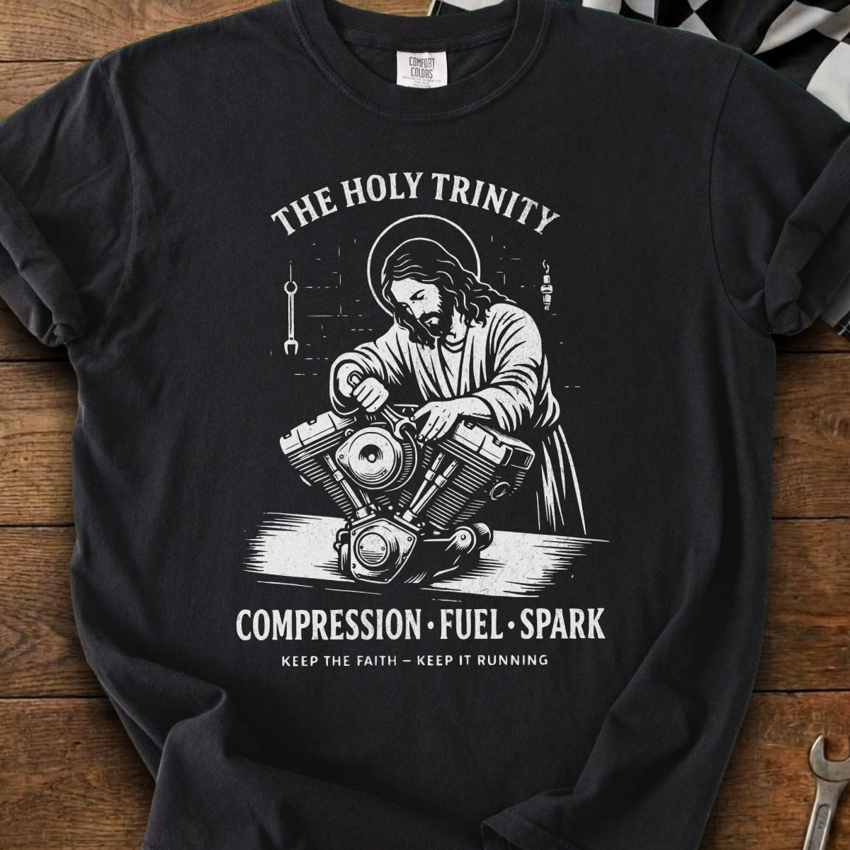 Jesus depicted working on a motorcycle engine with text "The Holy Trinity" and "Compression Fuel Spark".