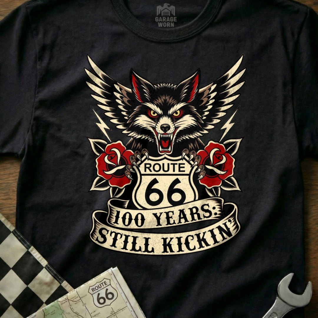 Black t-shirt with wolf, Route 66 logo, roses, and "100 Years: Still Kickin'" text.