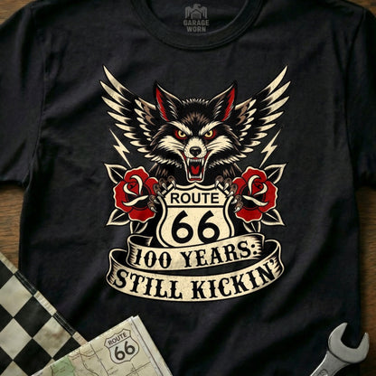 Black t-shirt with wolf, Route 66 logo, roses, and "100 Years: Still Kickin'" text.