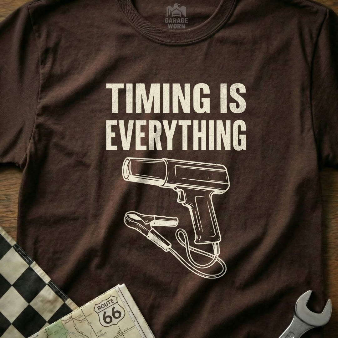 Brown t-shirt with "Timing is Everything" text and a timing gun graphic.