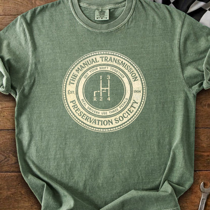 Green t-shirt with Manual Transmission Preservation Society graphic and shift pattern.